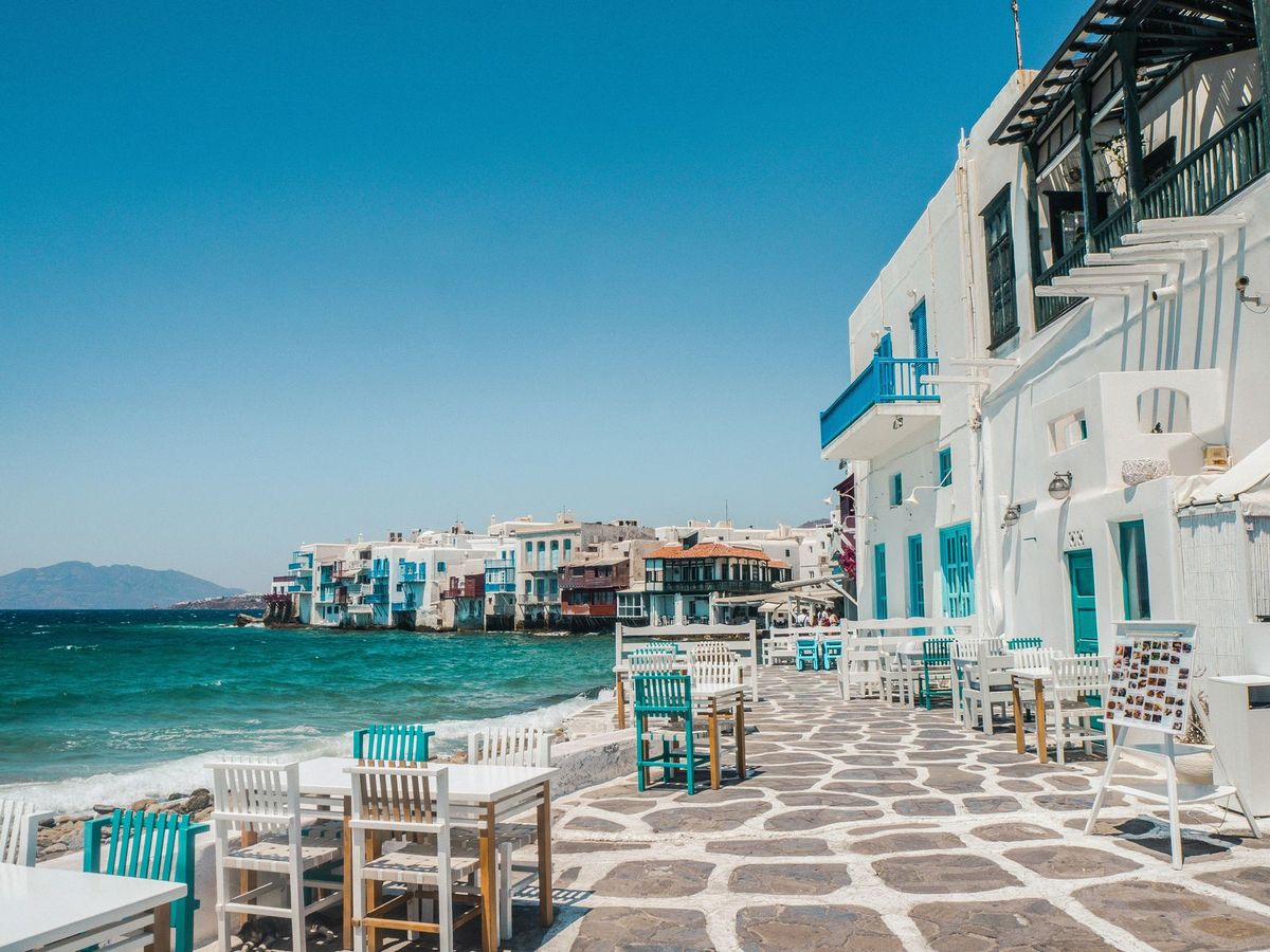 Whitewashed buildings and blue-green water along the waterfront in Mykonos, Greece