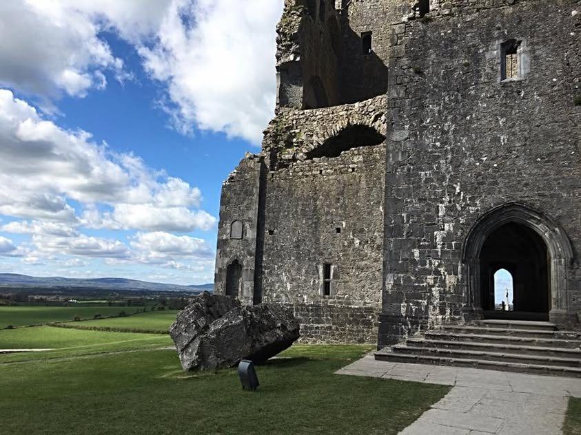 Castle ruins beside green fields in Ireland