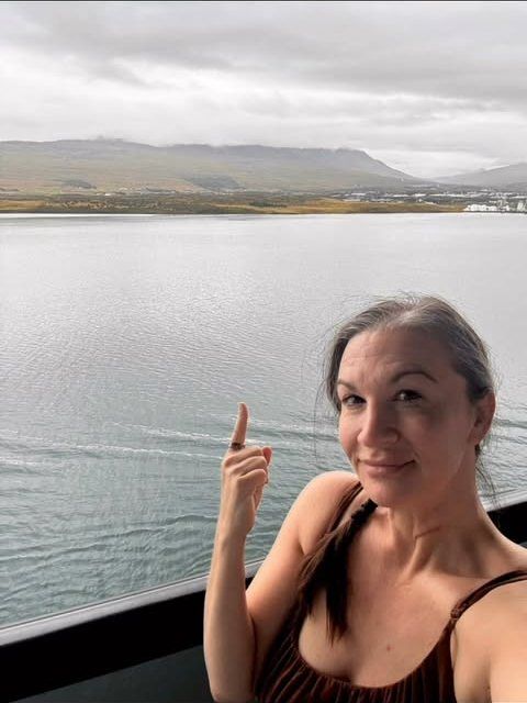 Libby on board a Virgin Voyages ship, with the sea behind her