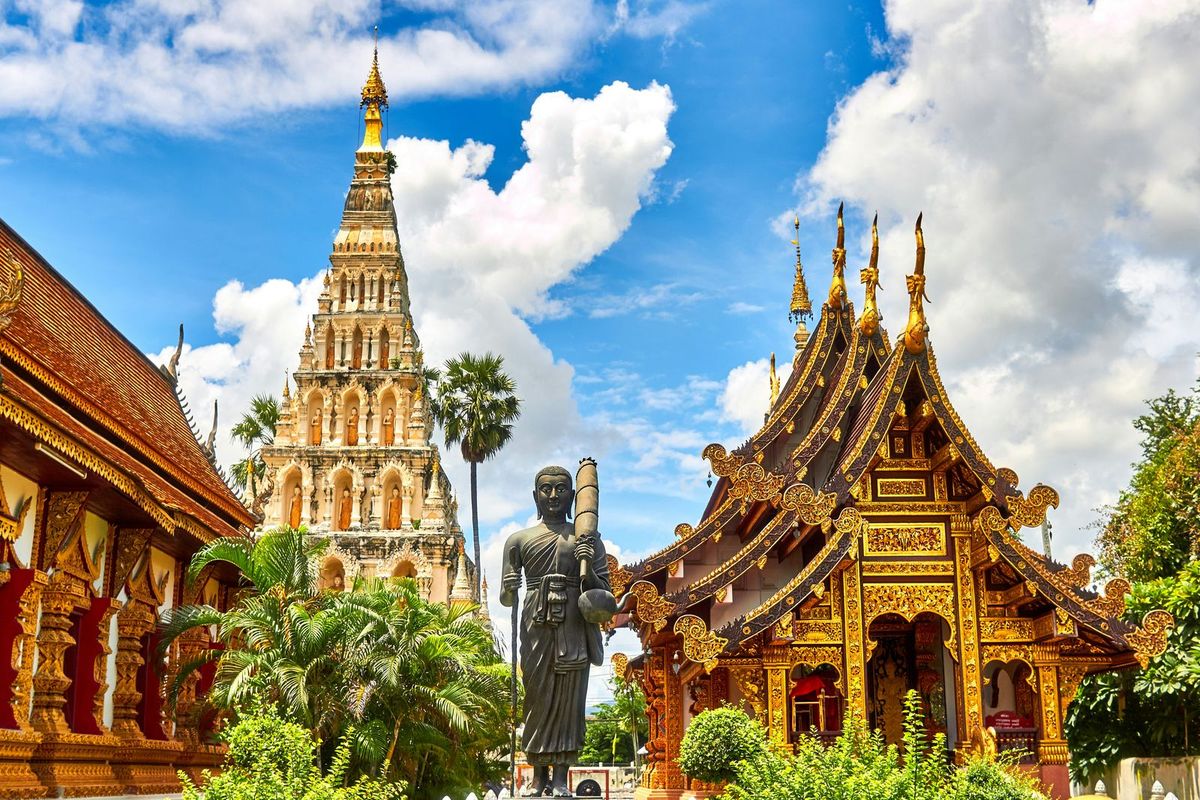 Golden temple rooflines and an ornate white chedi in Chiang Mai, Thailand