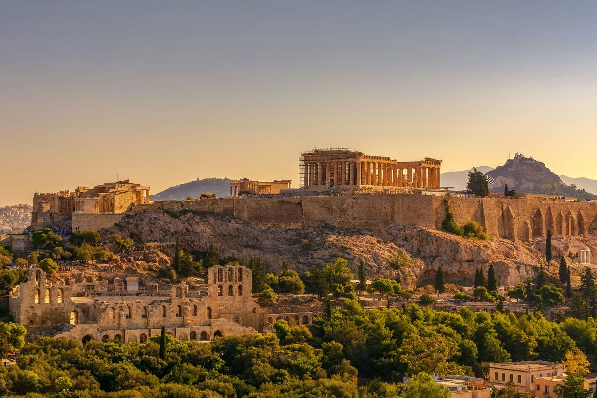 The Acropolis and Parthenon glowing at sunset above Athens, Greece