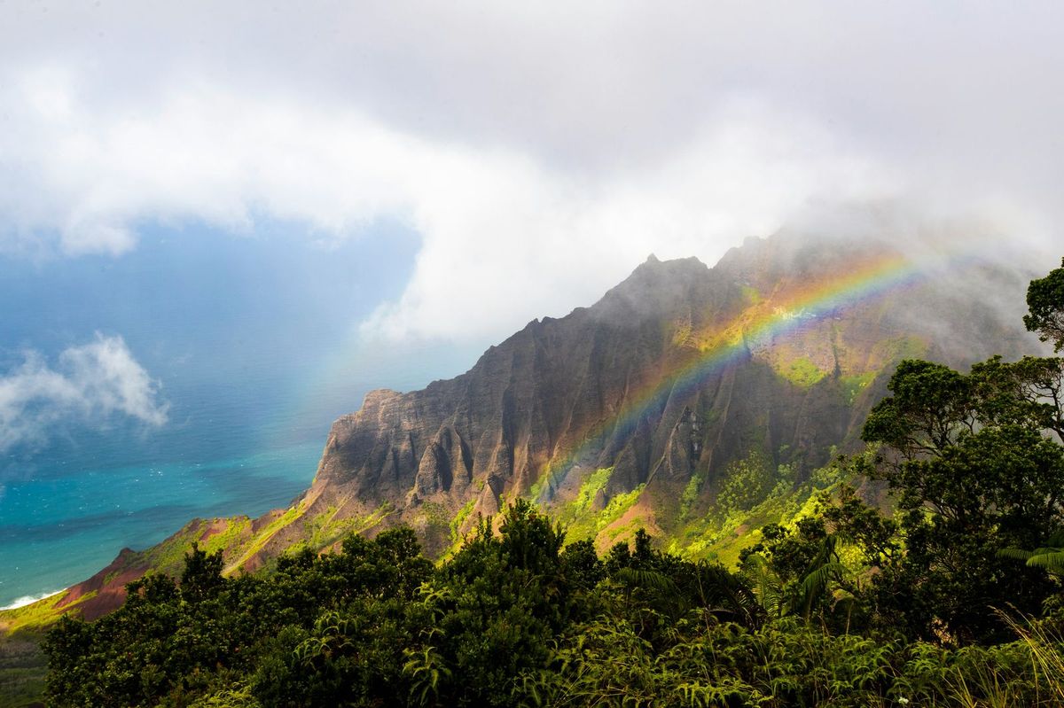 A rainbow over the green cliffs of the Nā Pali Coast on Kauai, Hawaii