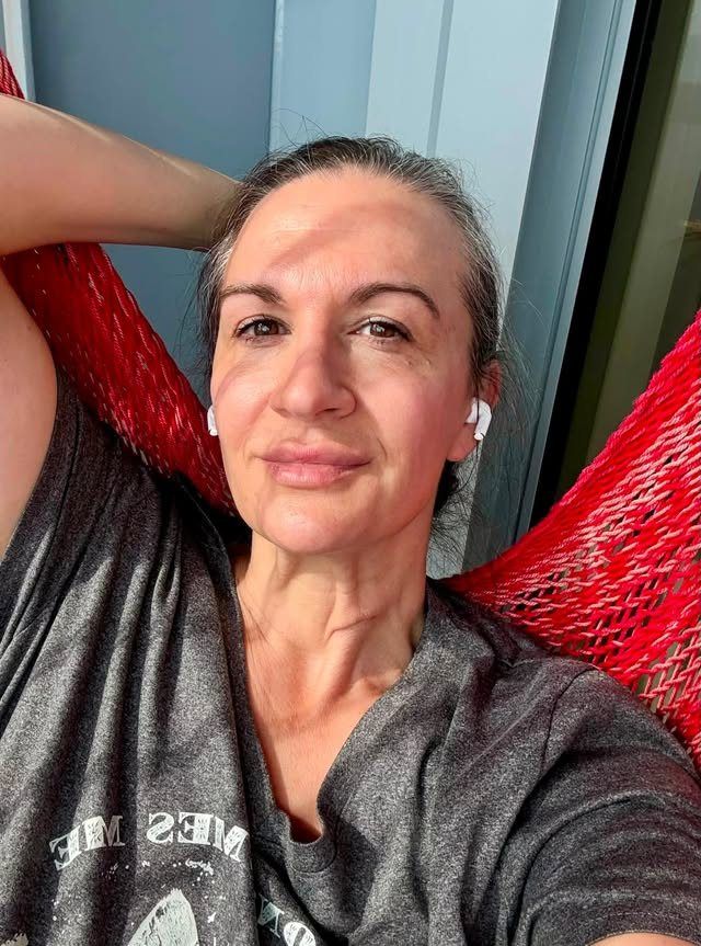 Libby relaxing in a red hammock on board Virgin Voyages
